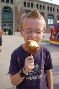 boy eating caramel apple on a stick