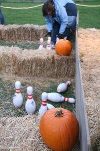 Volunteers helping with pumpkin bowling