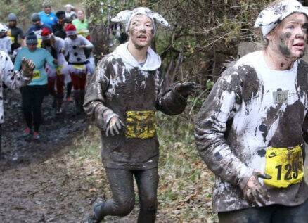 3 runners in sheep costumes covered in mud