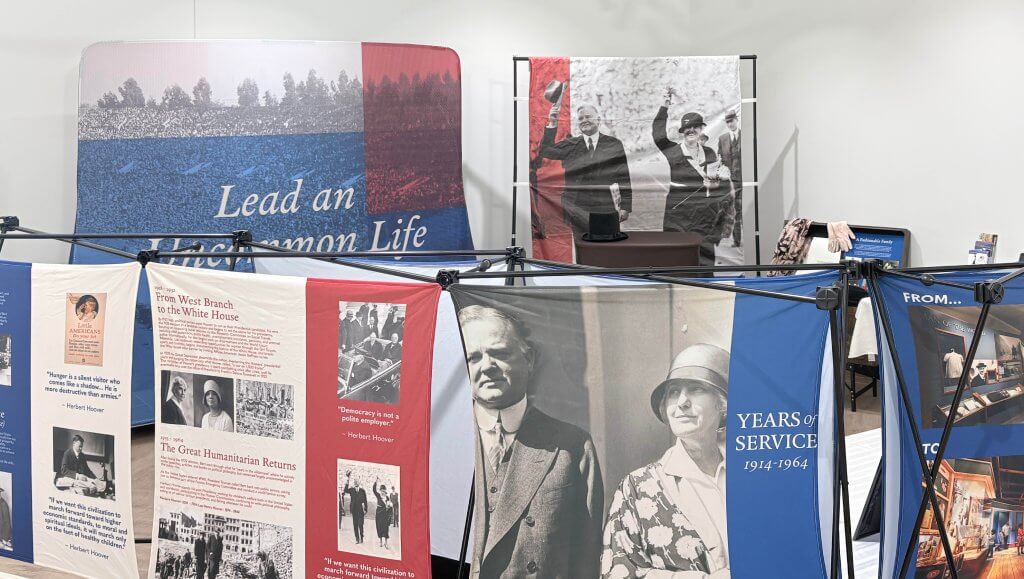 wide shot of exhibit showing multiple fabric panels with photos of herbert and lou hoover