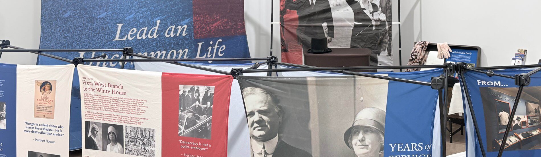 wide shot of exhibit showing multiple fabric panels with photos of herbert and lou hoover